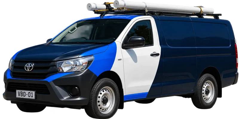 A licensed Randwick plumbing van loaded with pipe on the roof rack
